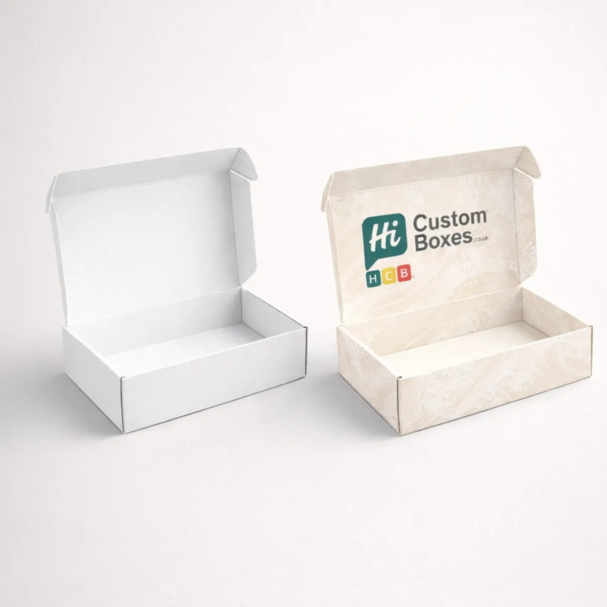 Two open mailing boxes- one plain white and one featuring a cream floral damask pattern with branding- class=
